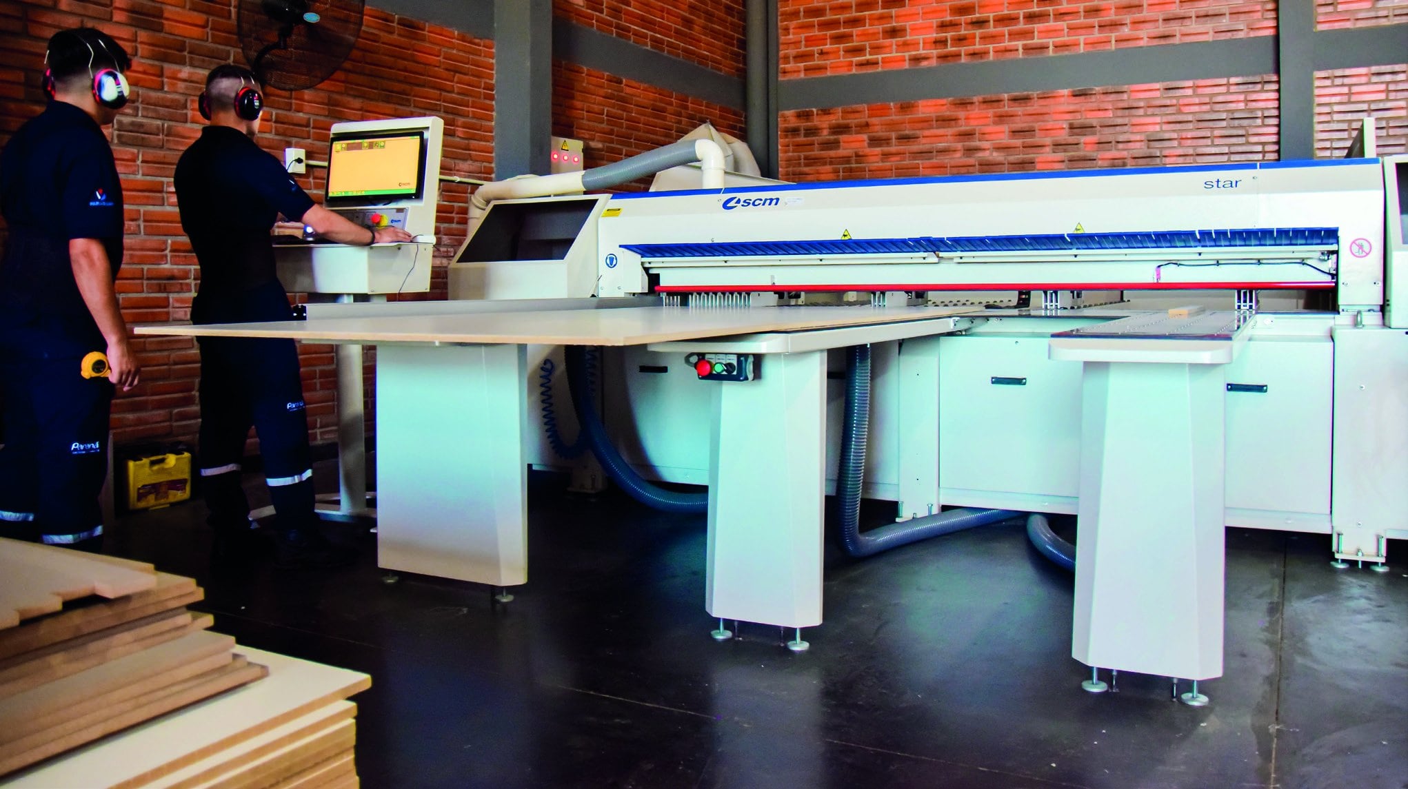 Operario frente a una máquina de corte de paneles en la industria