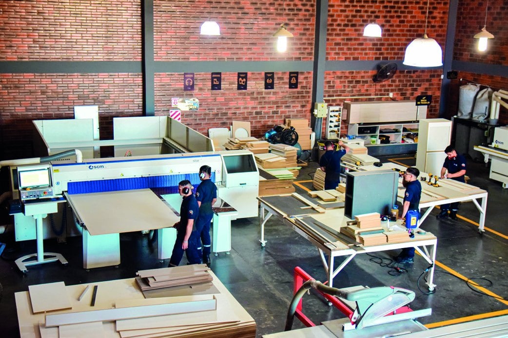 Taller de la industria con mesas de trabajo, maquinaria y operarios